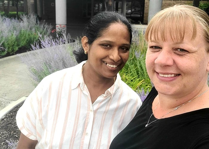 two females standing together smiling two females standing together smiling