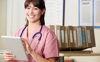 International nurse smiling holding a tablet International nurse smiling holding a tablet