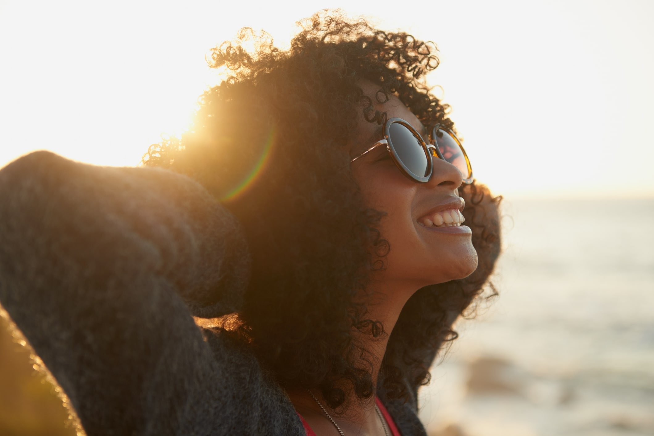 Happy young female on the beach with her face lifted towards the sun Happy young female on the beach with her face lifted towards the sun
