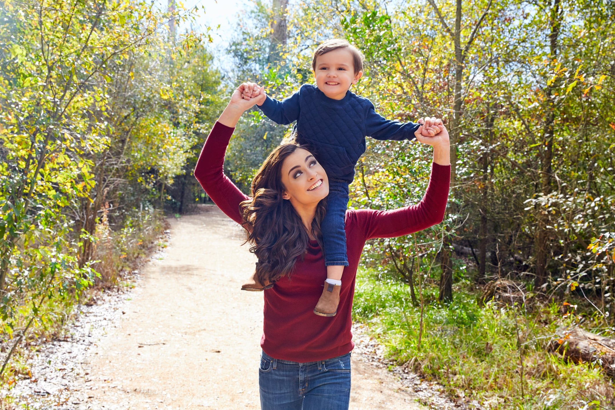 Kid boy sitting on mother's shoulders walking park Kid boy sitting on mother's shoulders walking park
